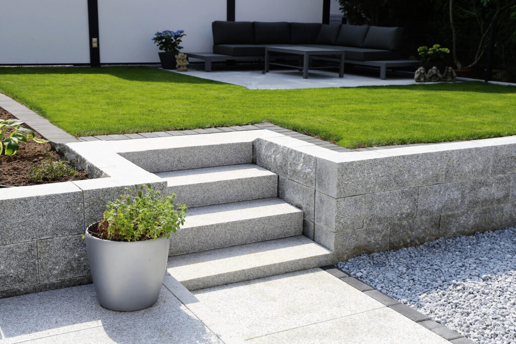 PaRe Garten- und Ladnschaftsbau Coburg GmbH -Sauber und ordentlich Garten mit Mauer aus Granit und solider Block Schritte